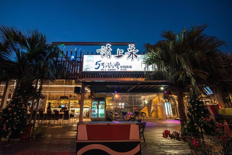 位於恆春的「請上車 5號港灣」景觀餐廳正門外觀，招牌燈光與椰子樹營造出南洋度假感