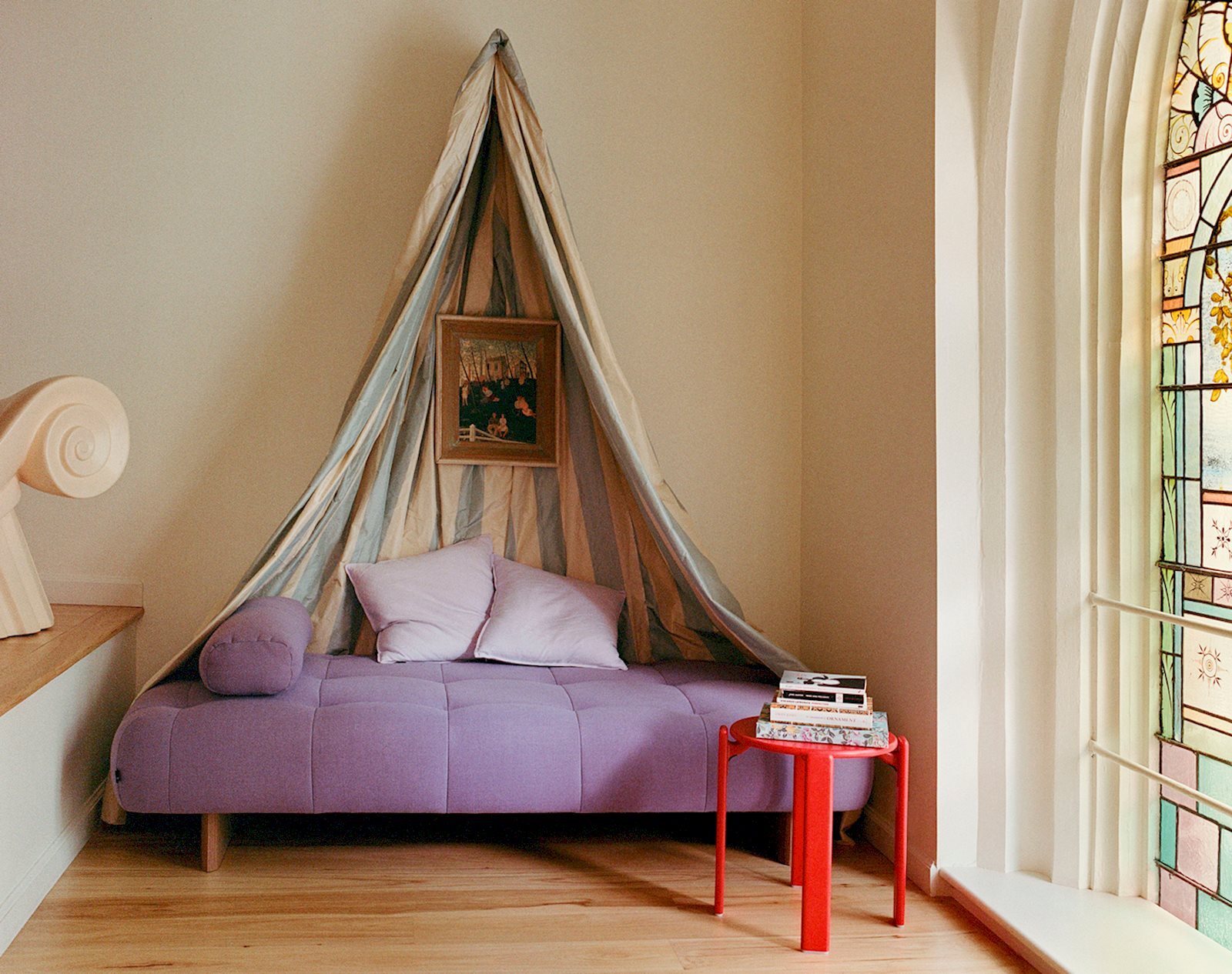 HAY Quilton 薰衣草色躺椅搭配 HAY Rey Stool,教堂彩繪玻璃窗旁閱讀角落。