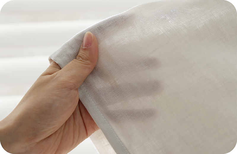 手部觸摸透氣布料,展現輕盈透光與極致親膚感