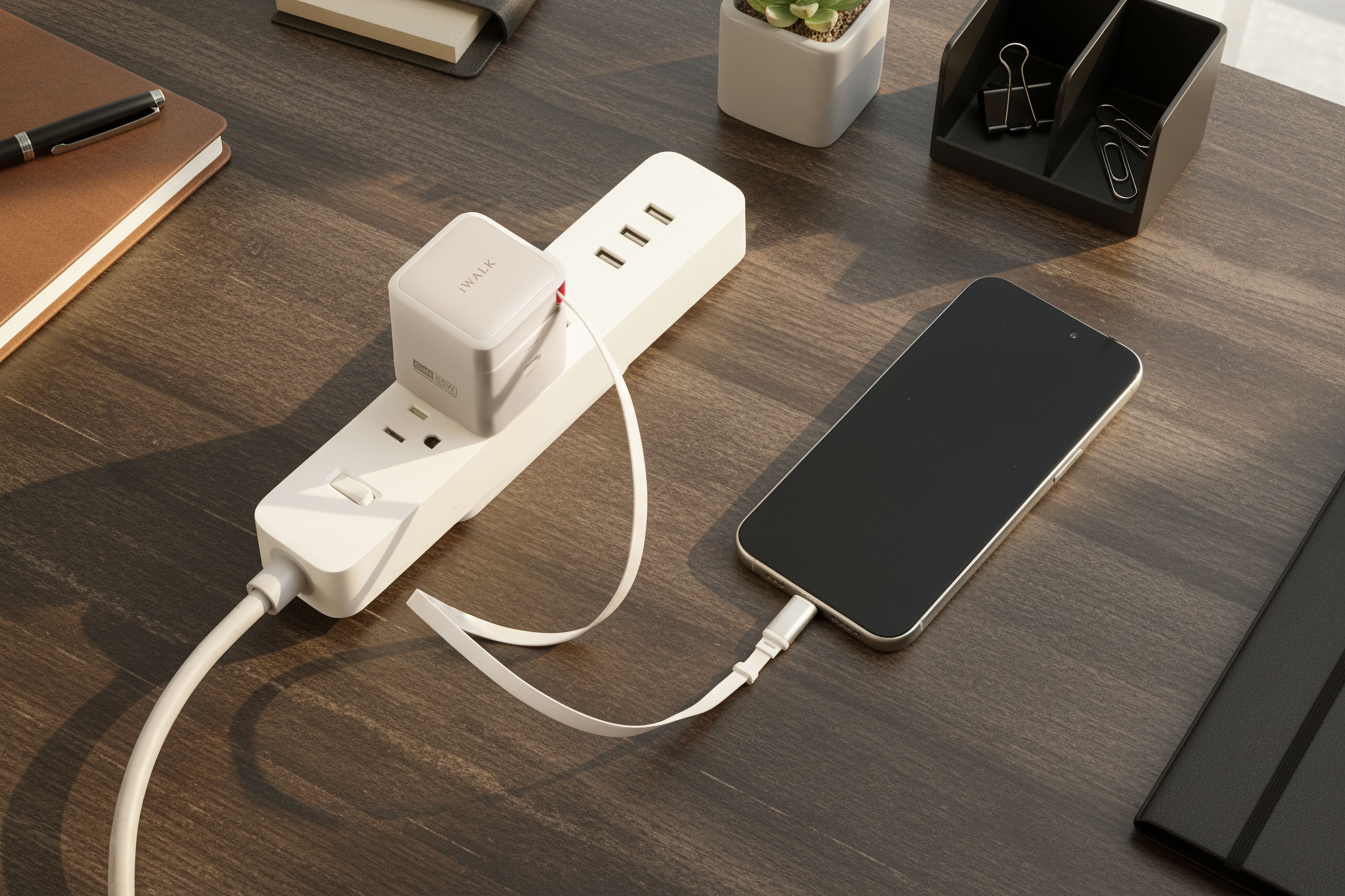 White iWALK charger plugged into an extension lead, with a white cable to a black phone