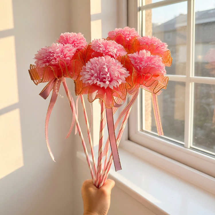 手握粉色康乃馨花棒在室內窗戶邊陽光照耀