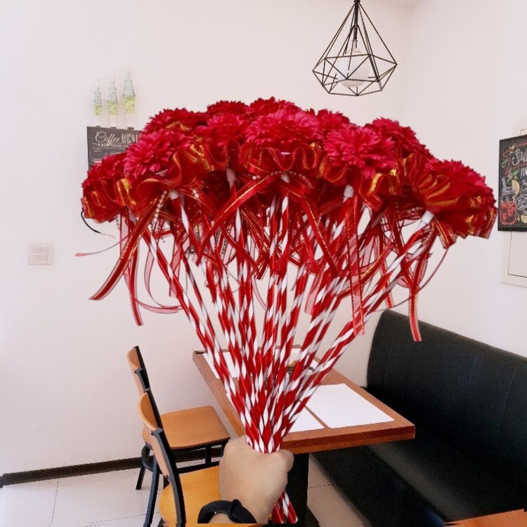 手握紅色康乃馨香皂花棒在簡餐店餐廳