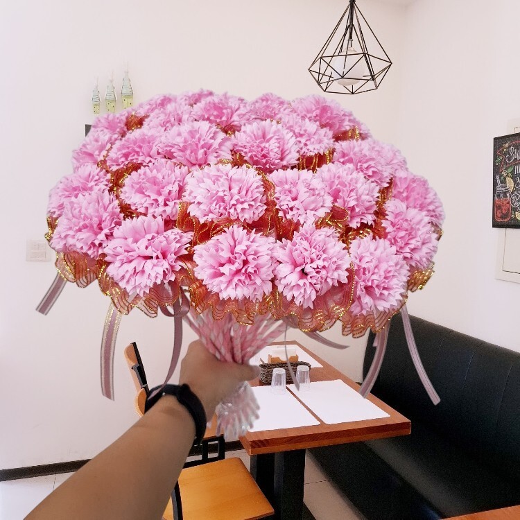 手握粉色康乃馨香皂花棒在簡餐店餐廳