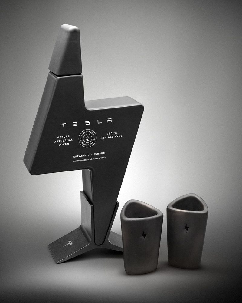Tesla Mezcal 限量梅茲卡爾酒，黑色閃電造型手工吹製玻璃瓶，標示 750ml、43% 酒精濃度，Espadín 與 Bicuishe 龍舌蘭混釀，附兩只刻有閃電標誌的黑色陶製酒杯，整組呈現墨西哥黑陶工藝質感。