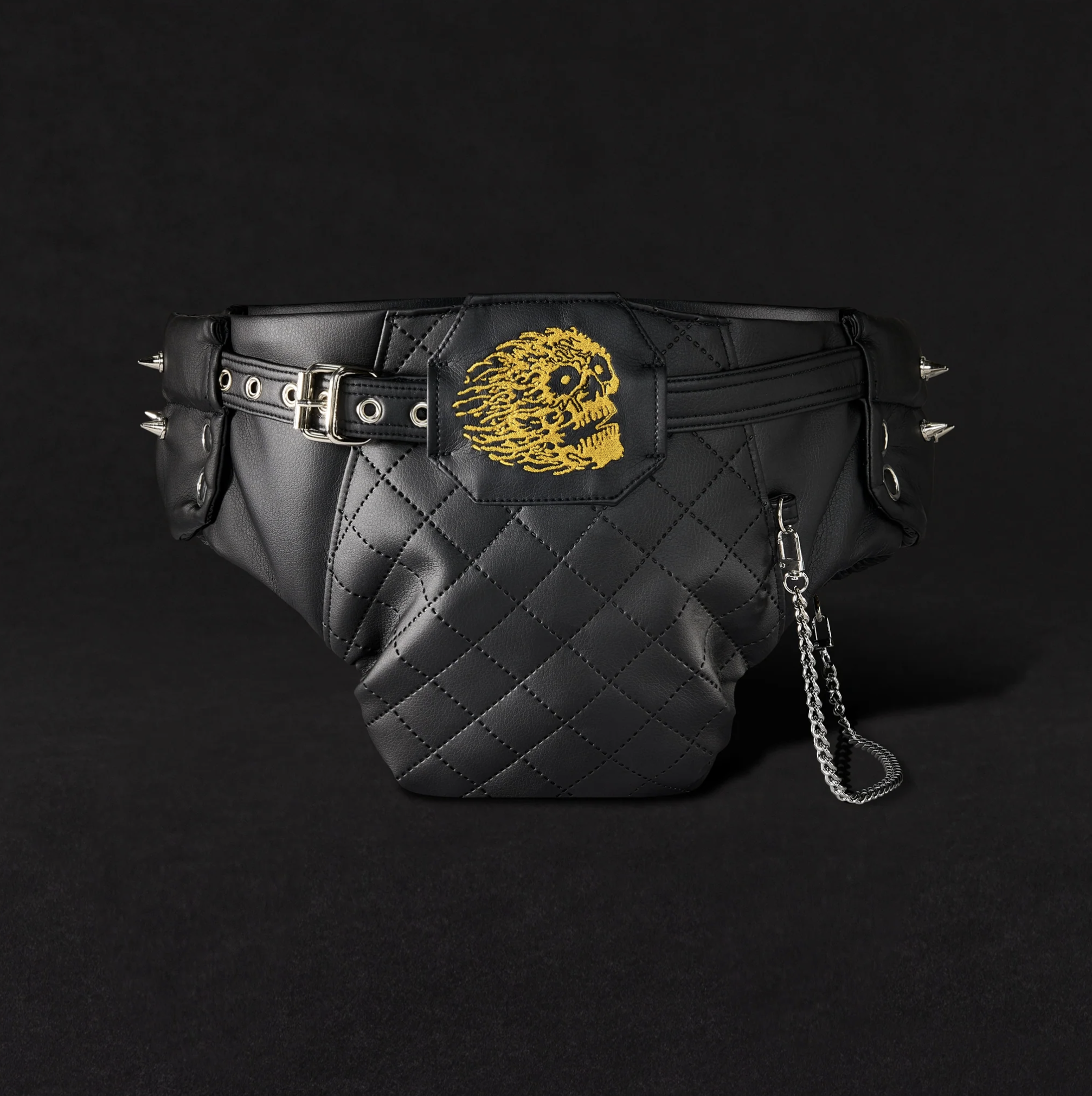 Liquid Death 與 Depend 聯名「Pit Diaper」成人尿布外層皮革配件，黑色菱格紋人造皮腰包造型，附銀色鉚釘、金屬扣環與鍊條，正面繡有金色火焰骷髏圖案，重金屬演唱會風格設計。