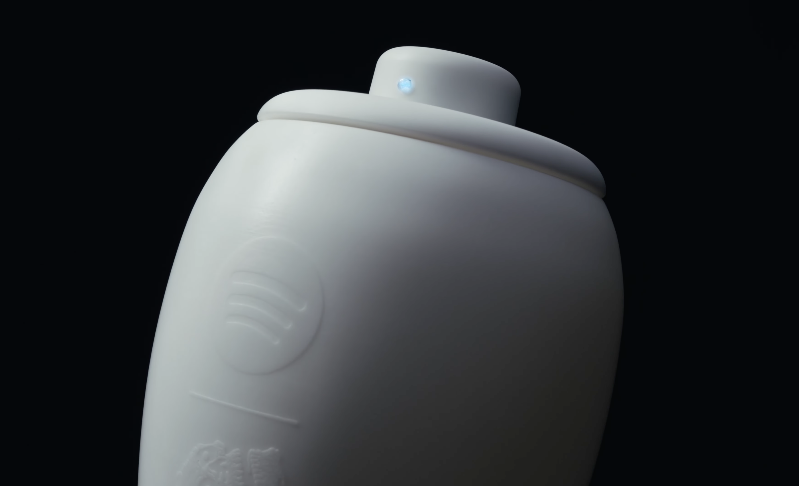 Eternal Playlist Urn 骨灰罈蓋頂近拍，藍色藍牙連線指示燈亮起，瓶身浮雕 Spotify Logo 清晰可見。