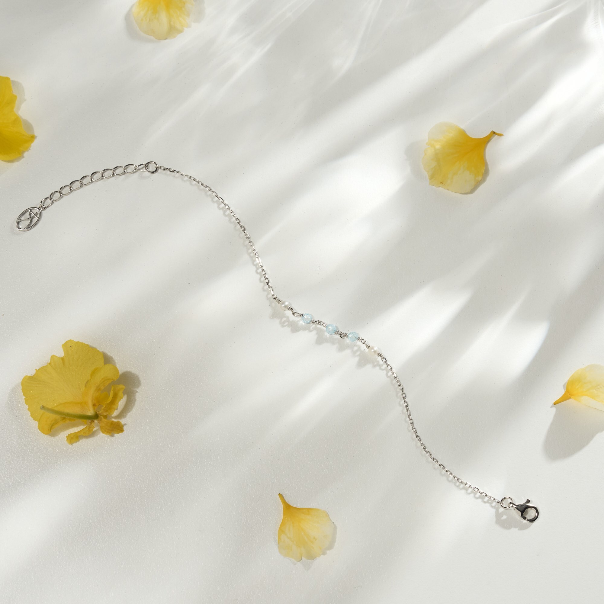 天然拓帕石與珍珠串珠而成的純銀水晶手鍊，拓帕石的淺藍色與珍珠白還可以提亮膚色與顯白，是很適合華人膚色的手鍊