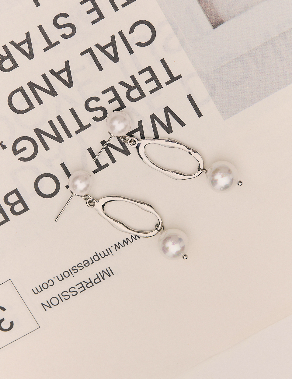 流線垂墜珍珠。針式耳環