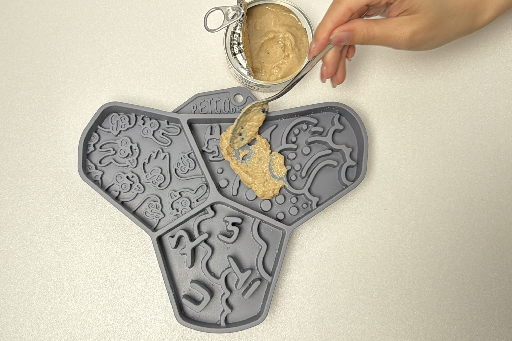 把主食罐抹在舔食墊上，讓狗狗舔食，達到紓壓的效果