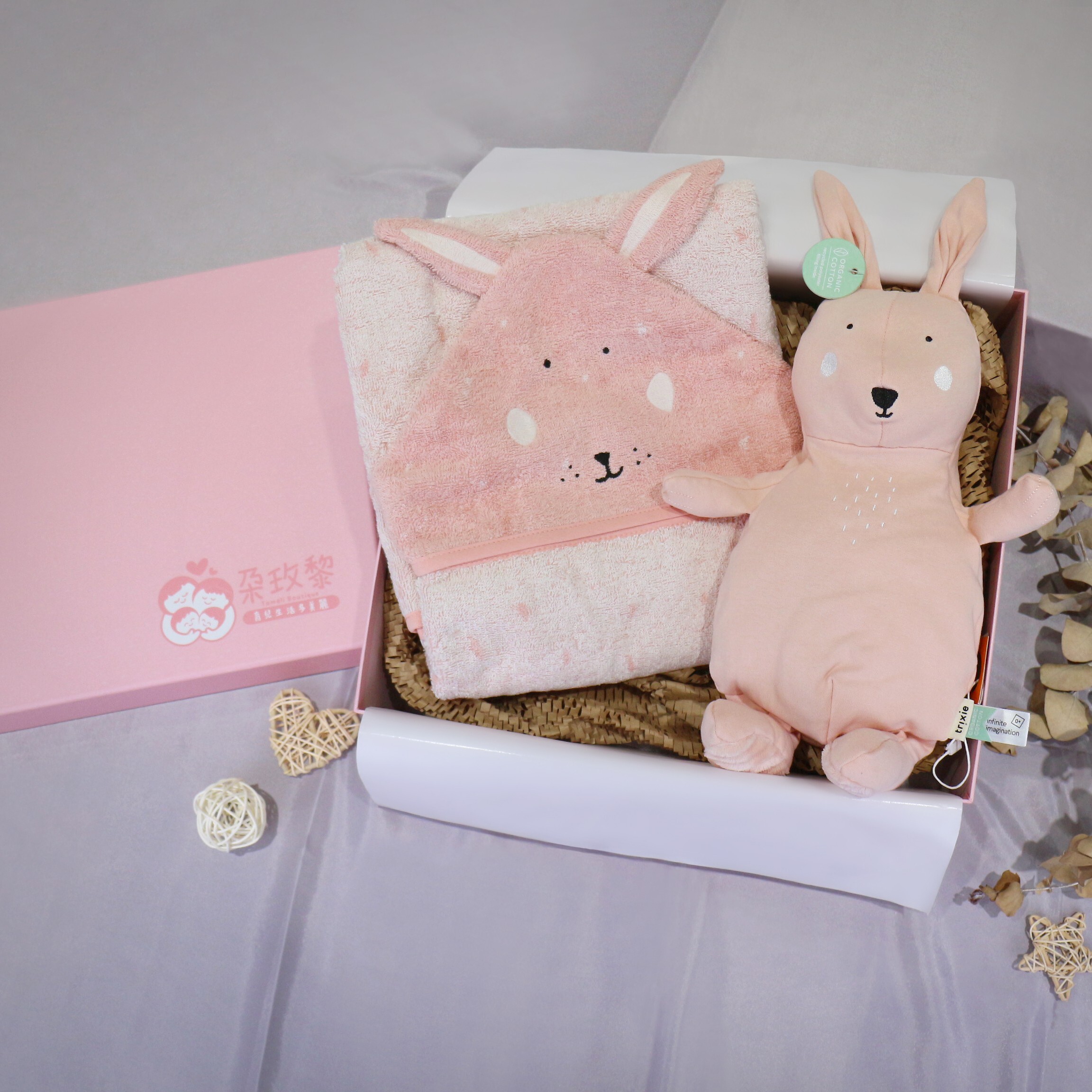 朶玫黎粉色彌月禮盒內裝有 trixie 粉紅色兔子造型嬰兒浴巾與同款安撫玩偶。 0–3 個月：親膚包覆與極致呵護