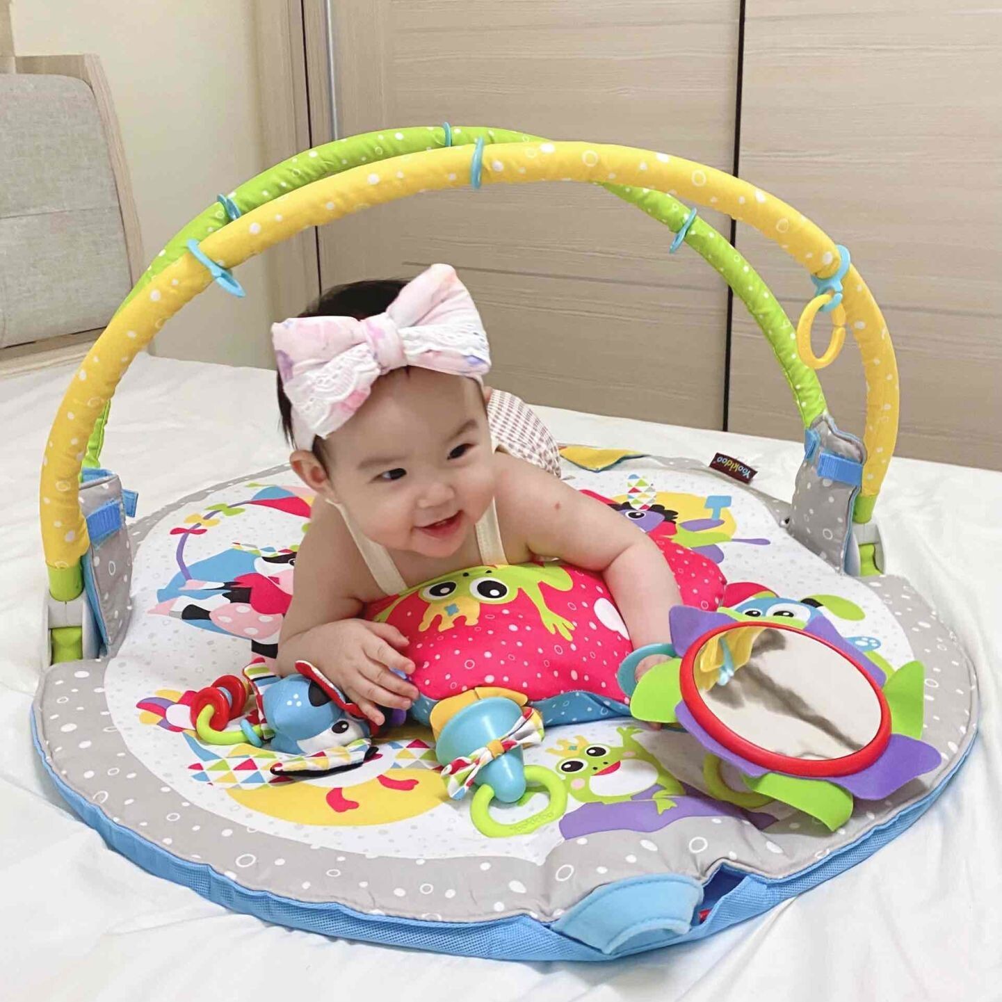 寶寶趴在 Yookidoo 健力遊戲墊上進行 Tummy Time，墊子結合豐富色彩、安全鏡與感統玩具。