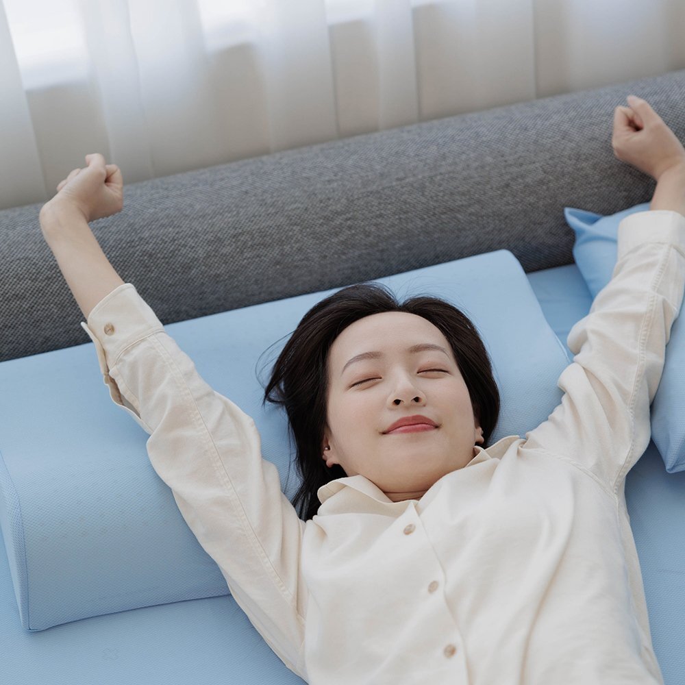 女性在森好眠吸濕排汗乳膠床墊上雙手上舉伸展，晨起神清氣爽不再被熱醒