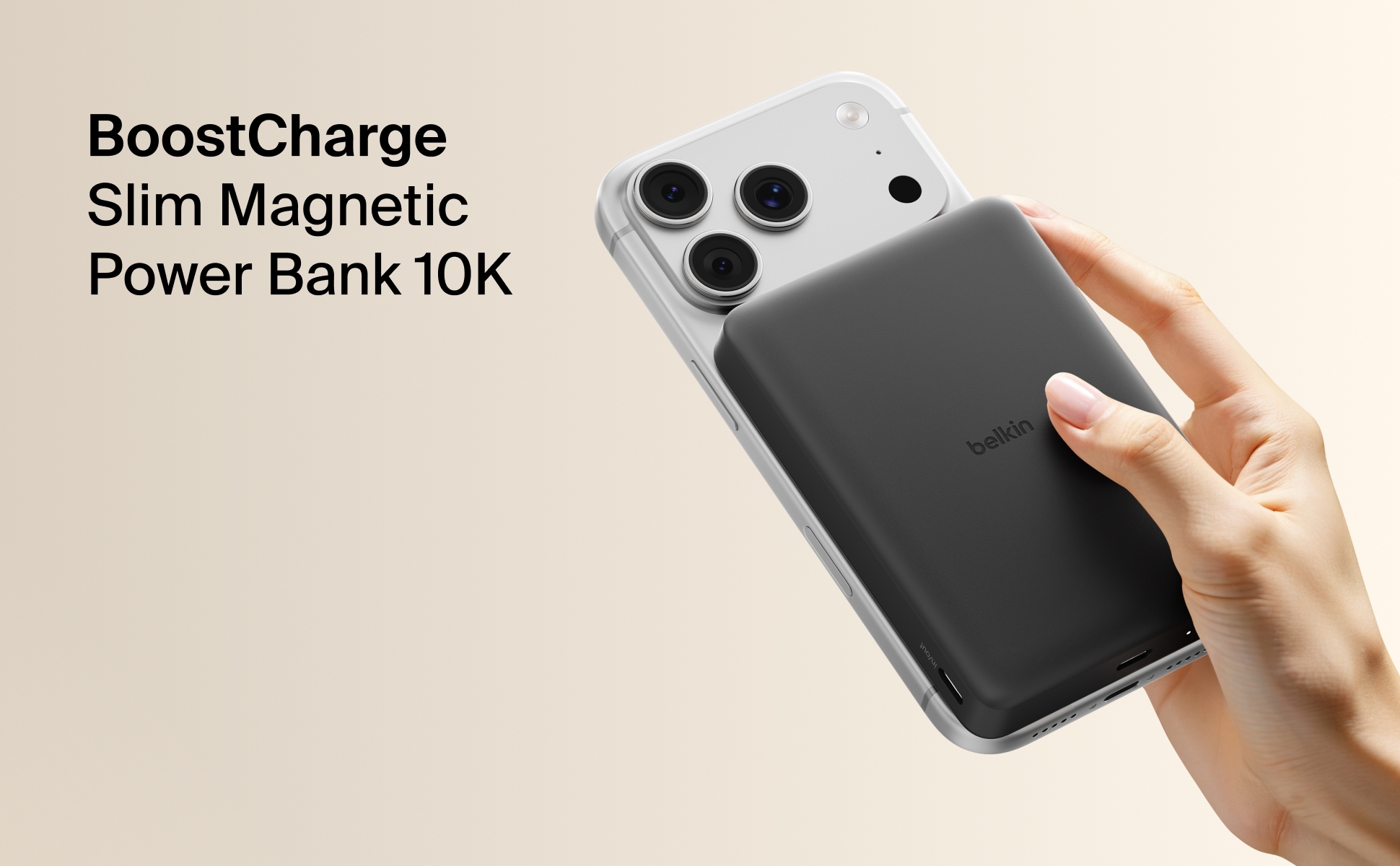 Belkin BoostCharge Slim Magnetic Power Bank 10K in black, attached to the back of an iPhone, showing its slim design and magn