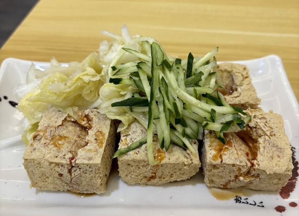 隨著夜市文化越來越熱鬧，臭豆腐也慢慢加入台灣自己的吃法，旁邊加上一撮高麗菜醃製的台式泡菜，酸甜解膩。