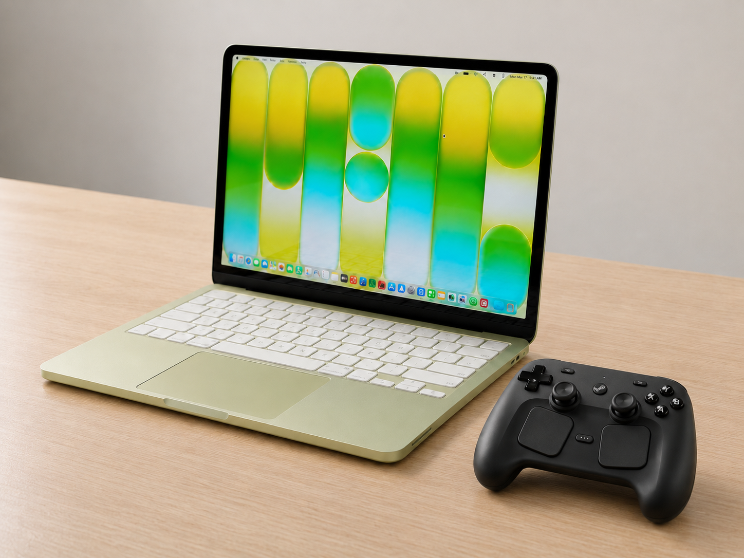 Steam Controller 2 代搭配 MacBook 使用情境示意圖，MacBook 開機顯示 macOS 桌面，旁邊擺放深灰色 Steam Controller，呈現 Mac 平台配對使用場景。