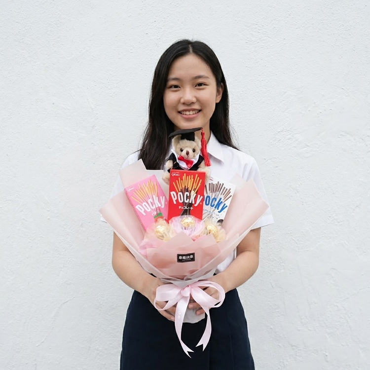 女學生拿pocky花束,在戶外乾淨的質感白牆