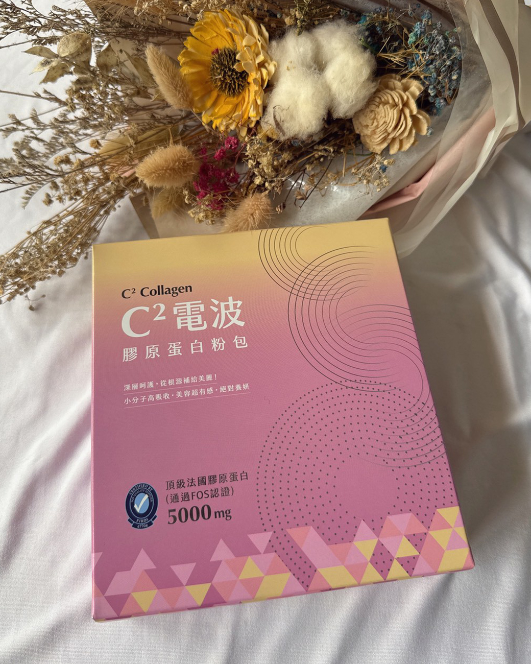 橙姑娘C2膠原蛋白的粉嫩外盒包裝,盒底清楚標示產品批號與有效日期以供查看。