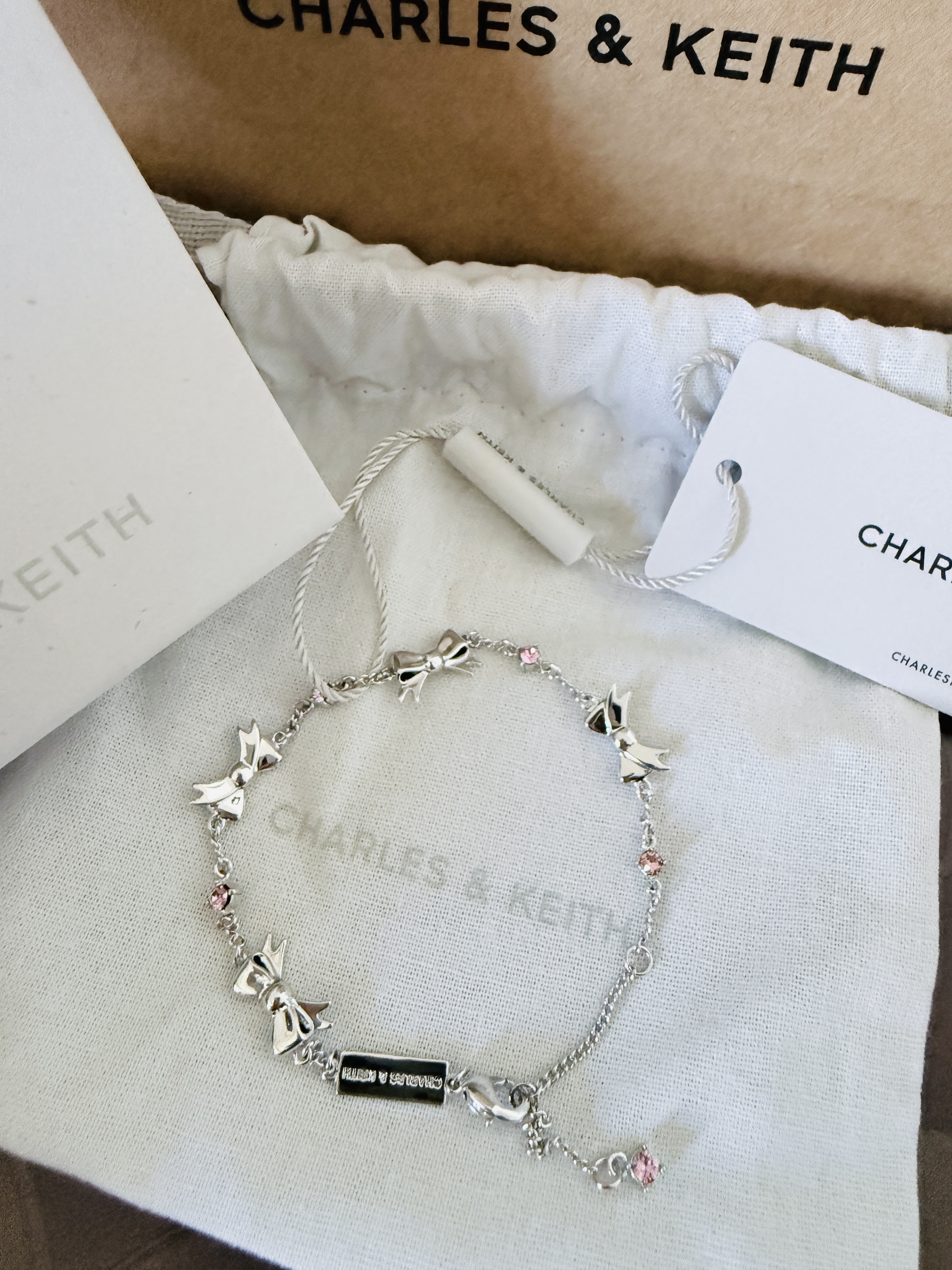 代購-CHARLES&KEITH 小ck 蝴蝶結系列 鑲鑽 可調節 黃銅水晶 手鍊 粉紅色Pink