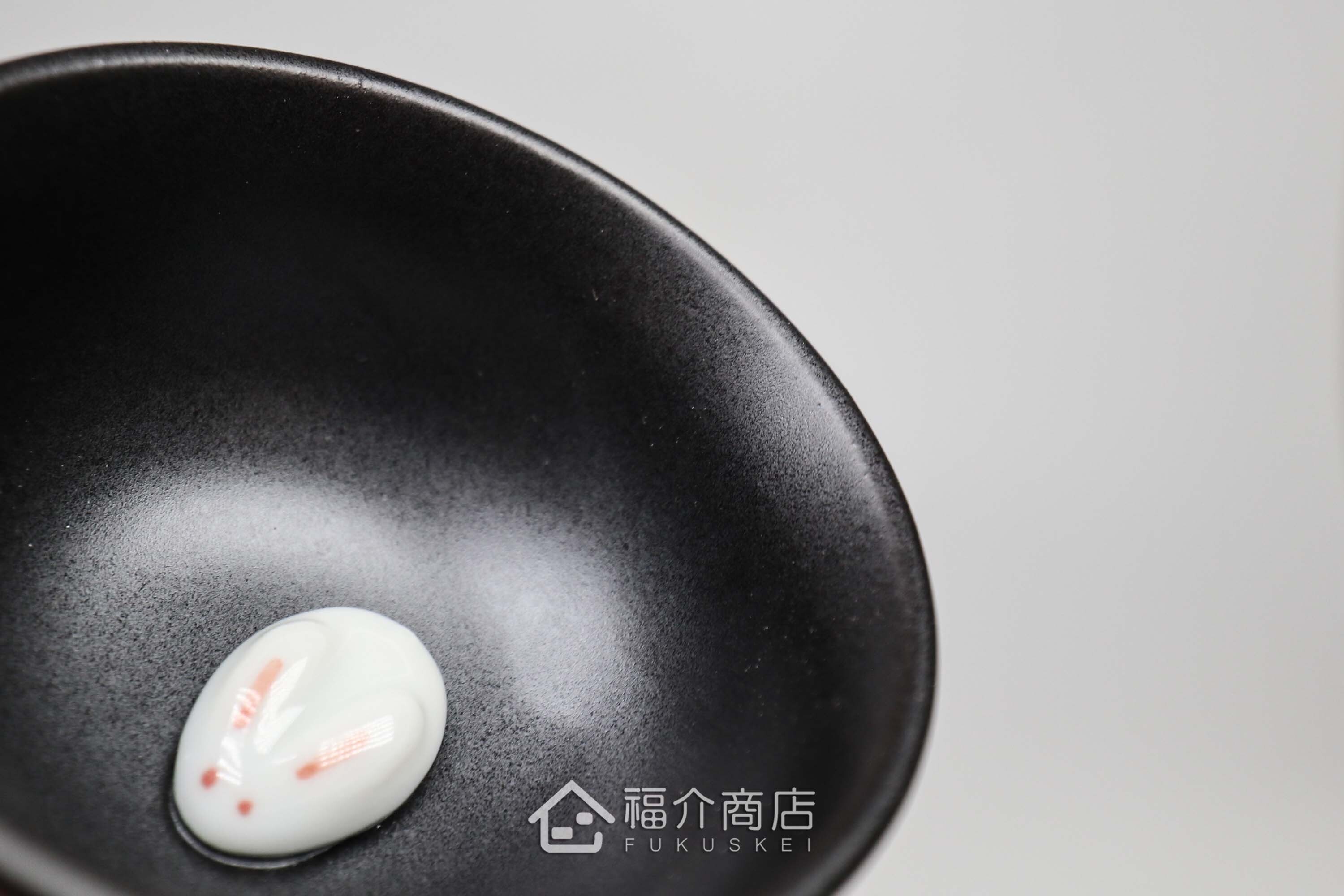 杯內有白兔造型的黑色清酒杯與黑色的月兔造型清酒壺