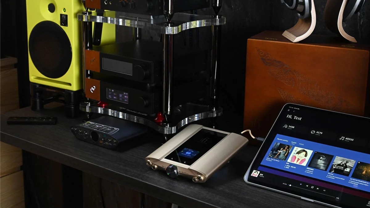 iFi Audio iDSD Valkyrie Bluetooth DAC Two audio components on a desk with speakers in the background and the iDSD Valkyrie