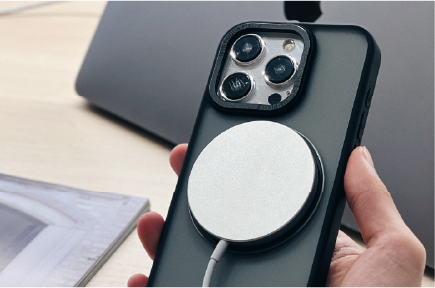 手持 YU 黑色手機殼，MagSafe 圓形充電器磁吸貼合背面、免脫殼充電
