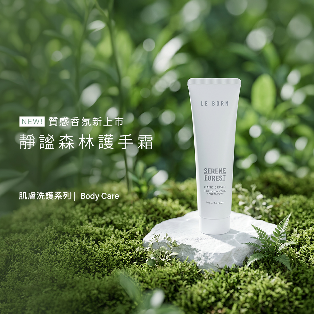 LE BORN 靜謐森林護手霜(Serene Forest Hand Cream)產品形象照。純白色的護手霜軟管垂直放置於白色的石塊裝置上,周圍環繞著綠色苔蘚與嫩綠的蕨類植物,背景呈現朦朧的綠意。左側文字為「NEW! 質感香氛新上市,靜謐森林護手霜」,傳遞清新、自然的森林感官氛圍。
