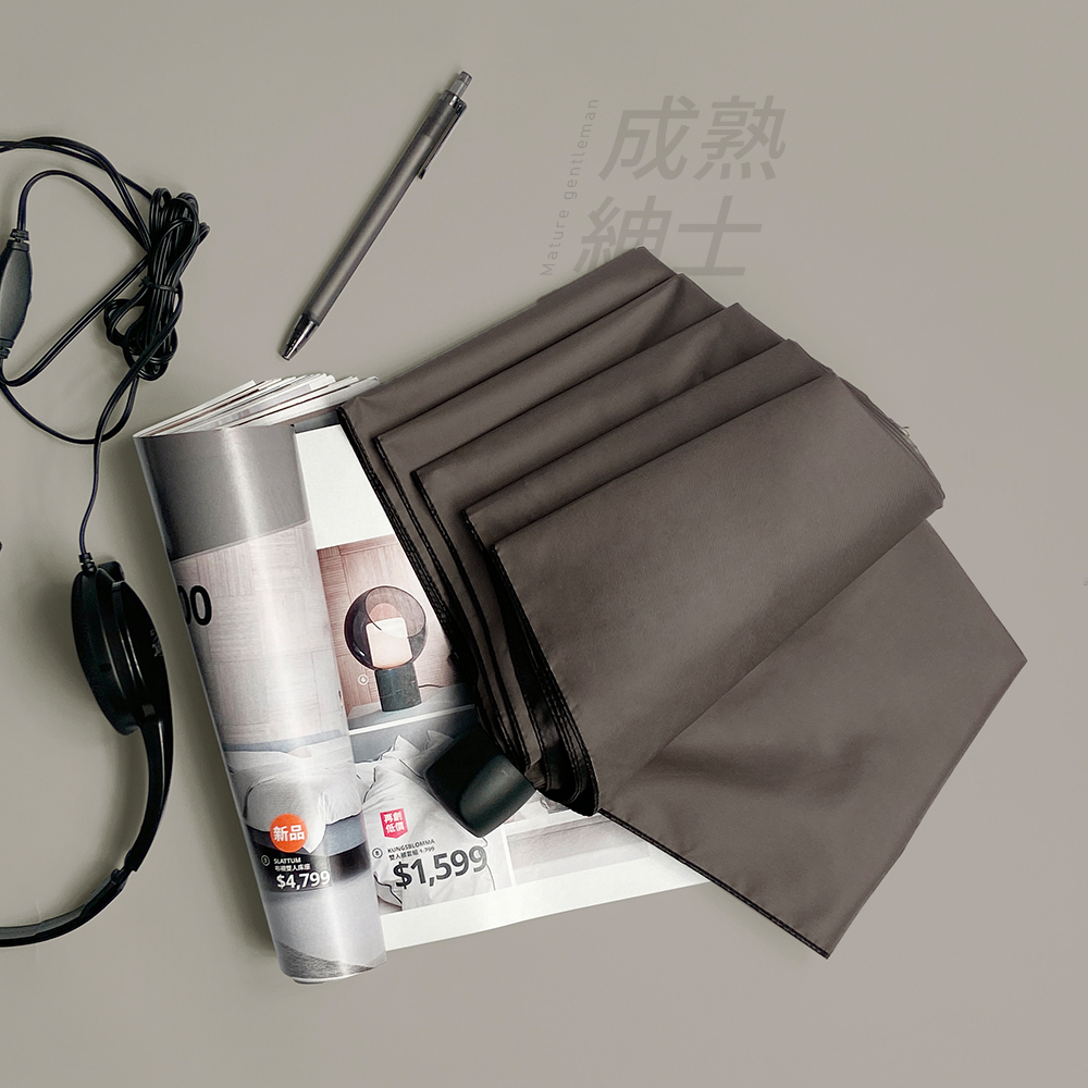 成熟紳士主題的灰色系雨傘展示圖。內斂的霧灰色背景上擺放著中灰色半開折疊傘