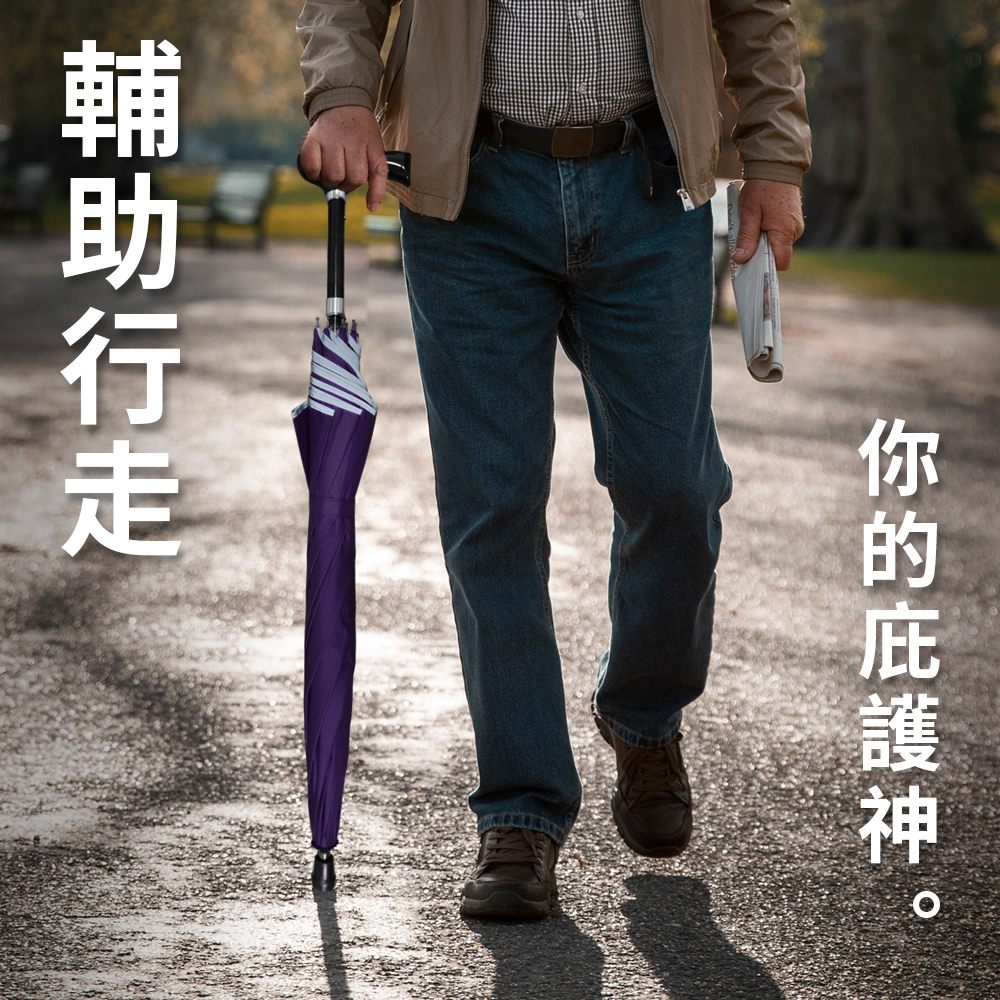 一名身穿夾克與牛仔褲的男子在公園步道上拿著一把登山輔助傘輔助行走