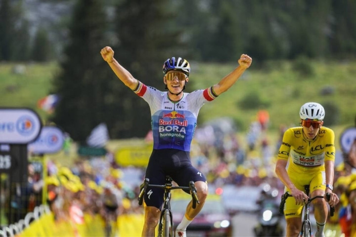 2026 環法 Stage 15 終點線前,Remco Evenepoel 高舉雙手慶祝奪下單站冠軍,後方為保住黃衫但未能拿下單站的 Tadej Pogačar。