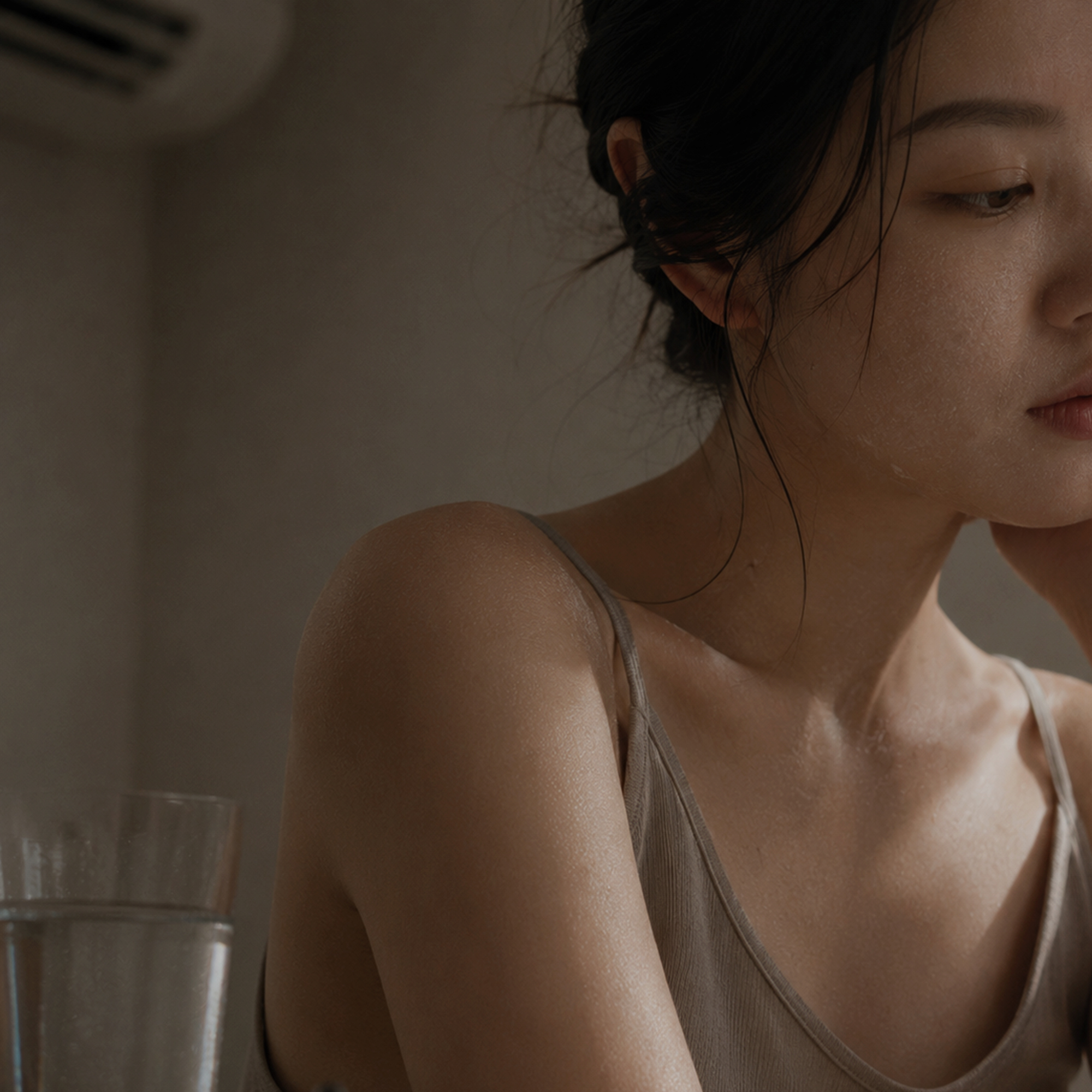 女性在乾燥環境中輕觸臉頰，呈現肌膚缺水緊繃與疲憊狀態