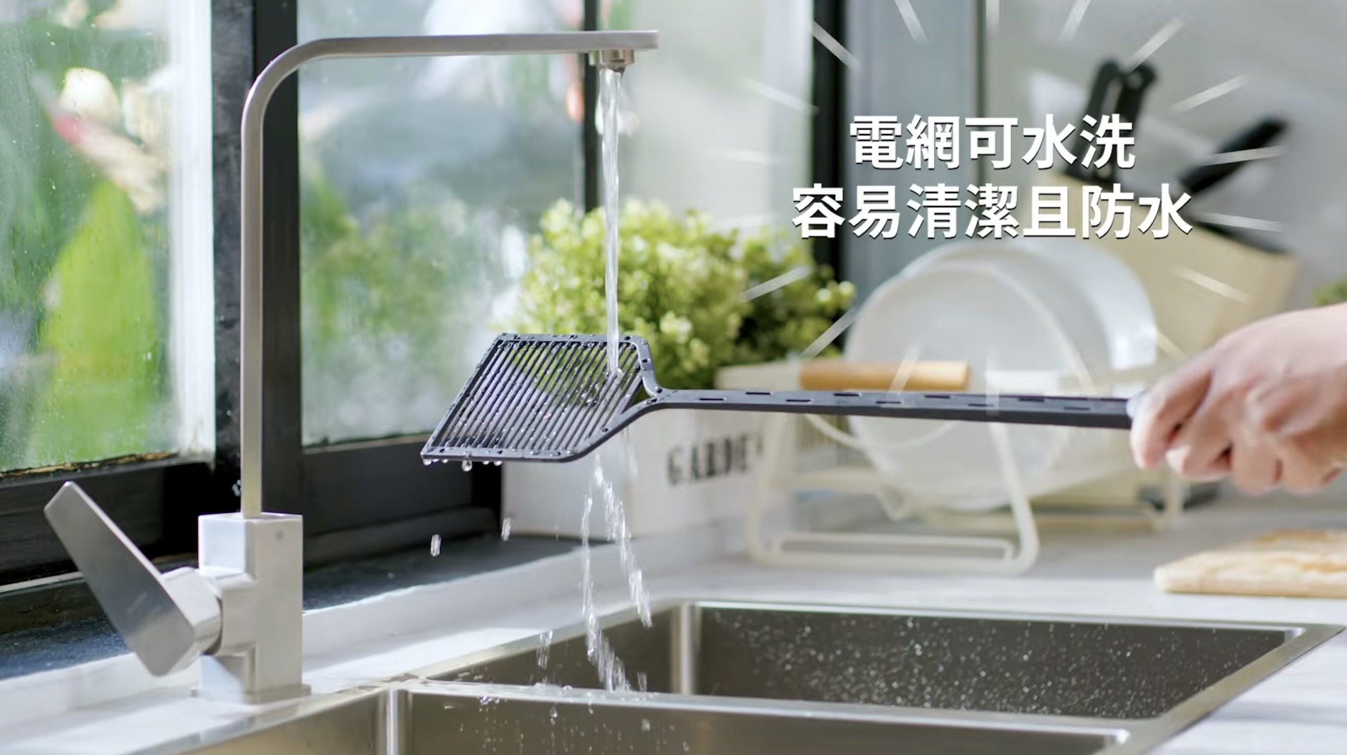 電蚊拍電網喺水喉下沖水，並用布抹乾