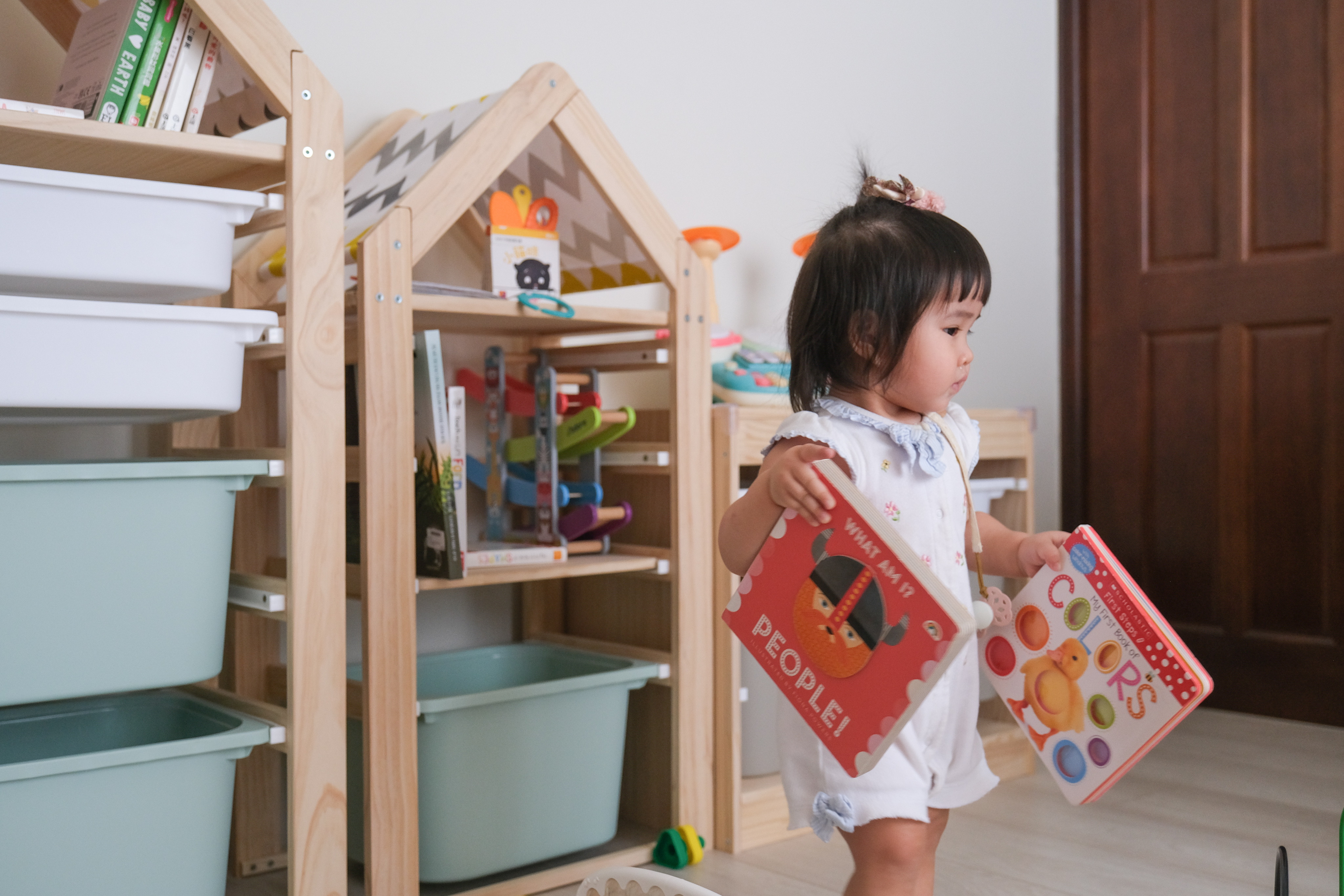 幼兒從實木收納櫃拿取繪本