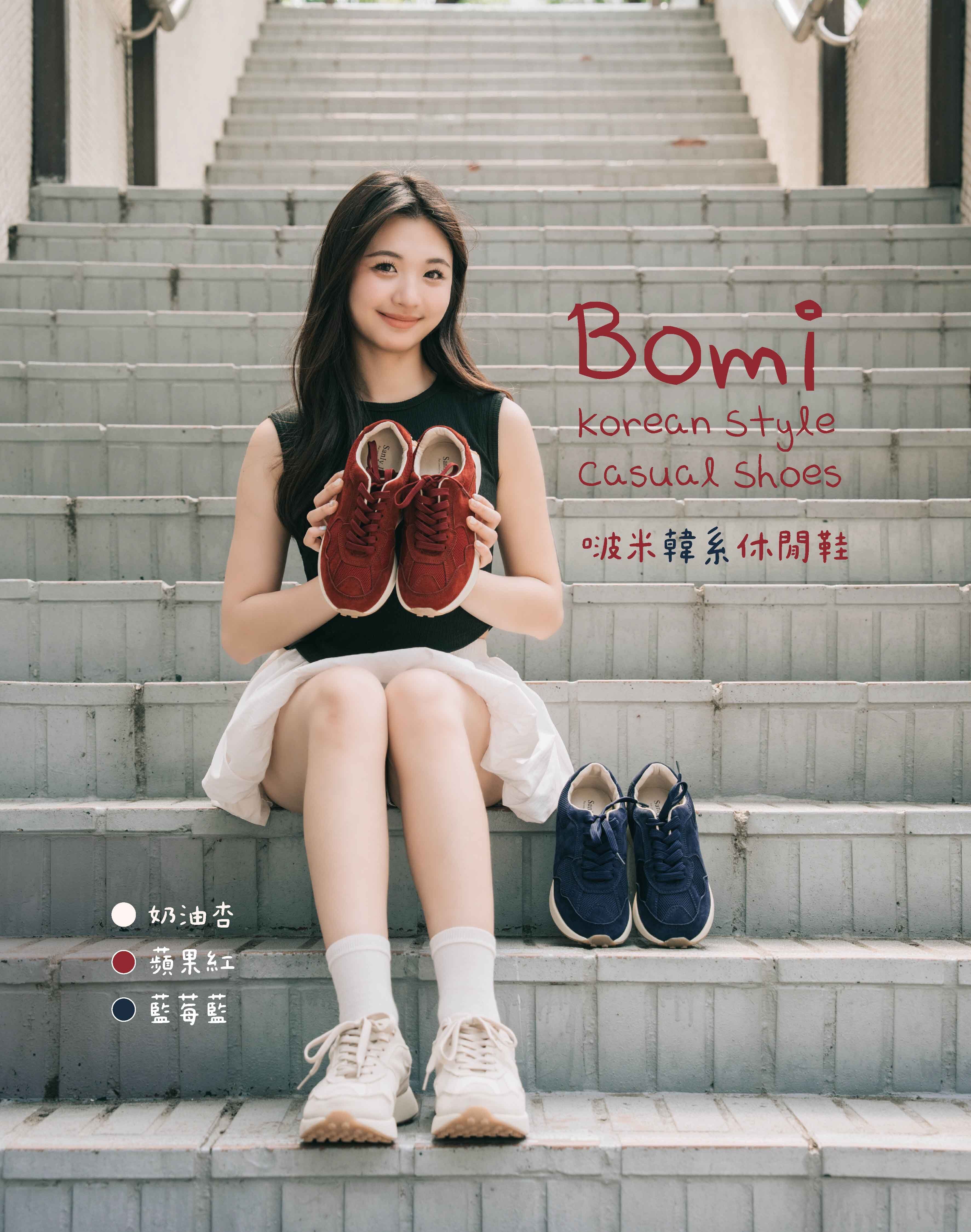 穿著白裙的年輕女子坐在戶外樓梯上，手裡拿著一雙Sanly Joy波米韓系休閒鞋（蘋果紅），腳上穿著奶油杏色，旁邊放著藍莓藍色。