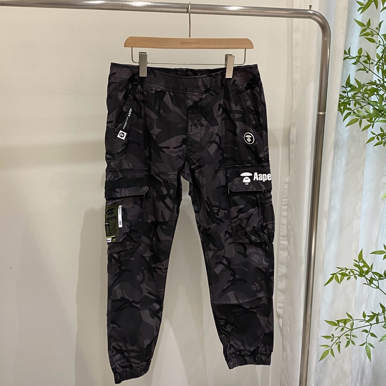 Aape 滿版迷彩草寫大字束腳工裝長褲 M6828XAI