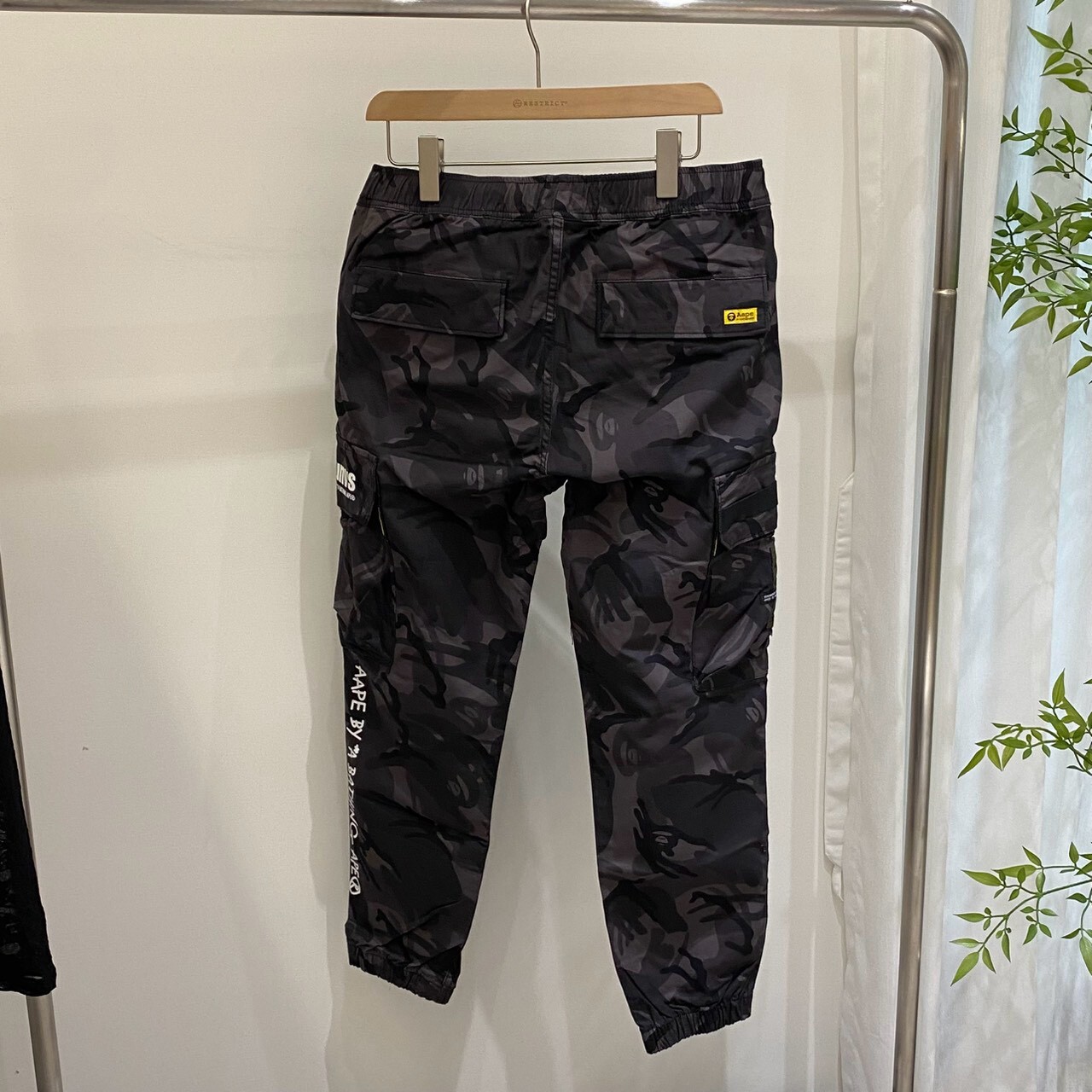 Aape 滿版迷彩草寫大字束腳工裝長褲 M6828XAI