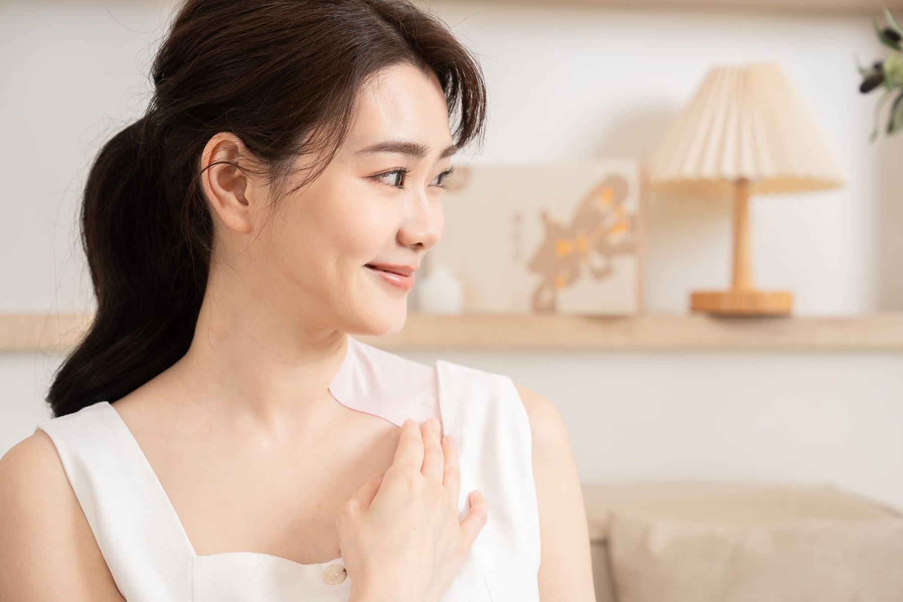 鎖骨貼著貼布、神情放鬆側看的女性