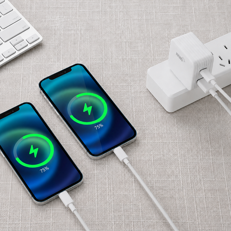 白色 HANG 快充頭插在延長線上，同時為兩支 iPhone 充電，畫面顯示充電中