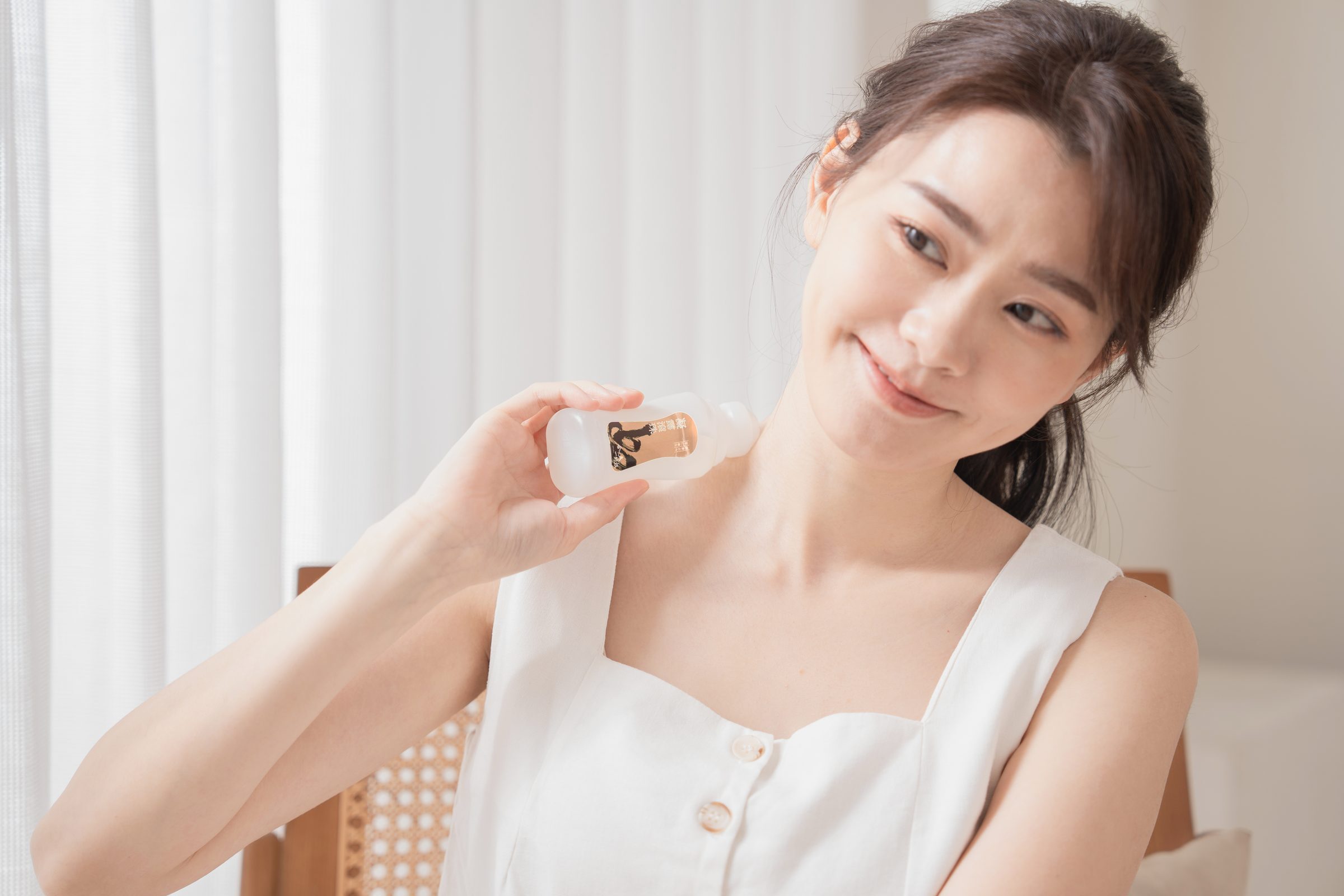 手持洋甘菊凝露滾珠、滾過肩頸的使用情境