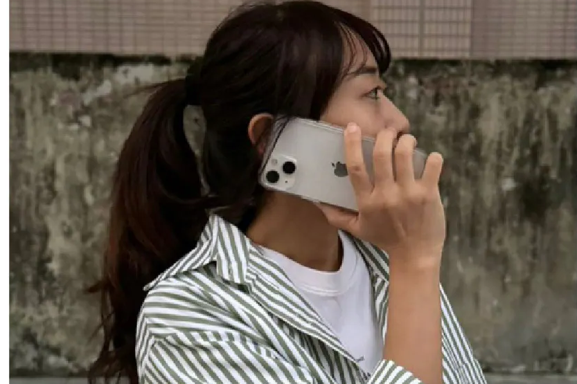 蘇沛阿香在戶外街邊用裝上極地冰岩殼的 iPhone 講電話