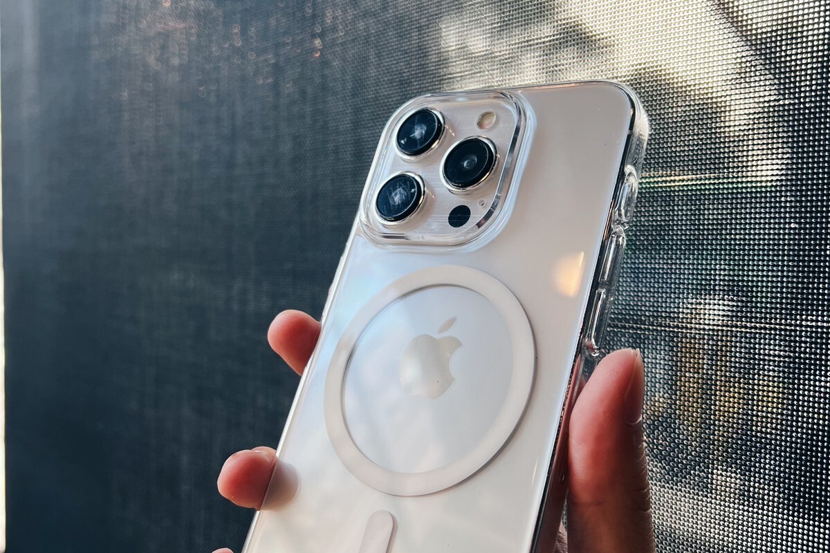 手持透明極薄殼 iPhone，鏡頭開孔與側邊按鍵開孔清晰可見