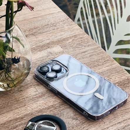藍色 iPhone 搭配透明零手感 Lite Case 平放木質桌面，背面 MagSafe 磁環清晰，旁有磁吸配件