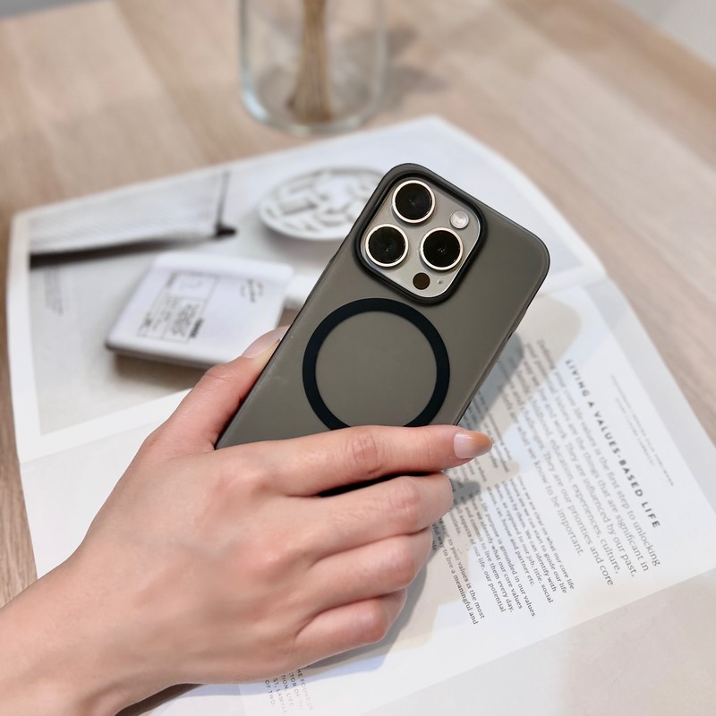桌面文件上的黑色磨砂超薄殼 iPhone，背面吸附 MagSafe 磁吸配件