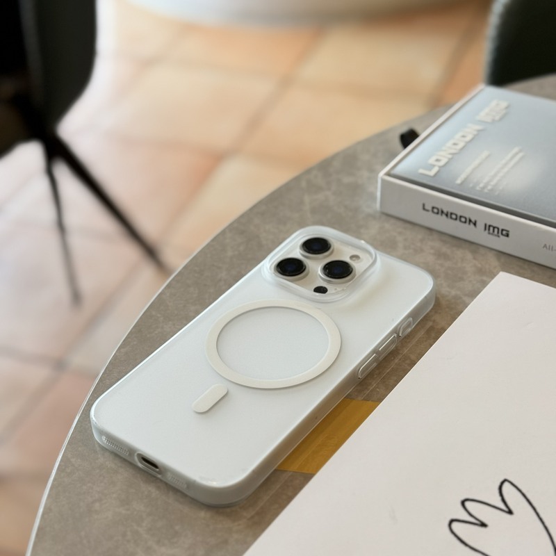 白色磨砂超薄殼的 iPhone 立於咖啡廳桌邊，霧面殼身低調不反光
