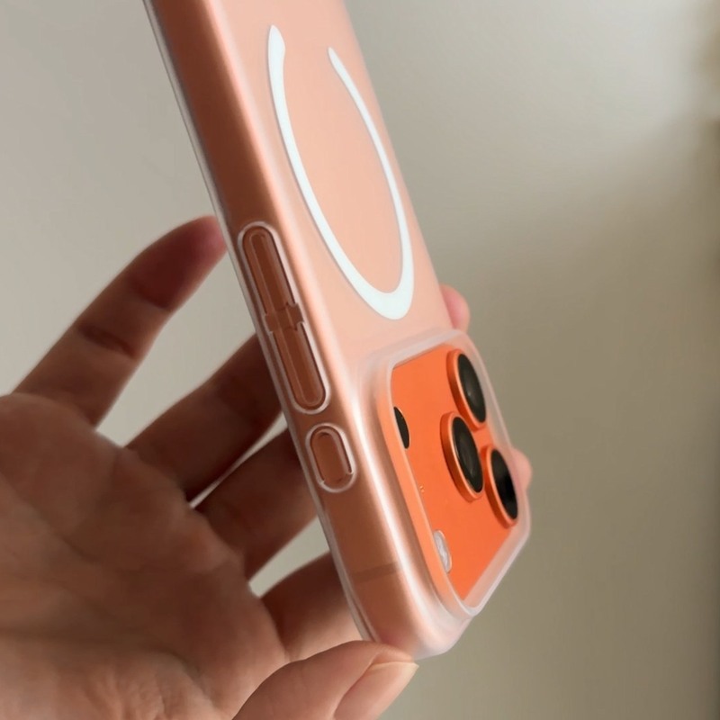 手持橘色磨砂超薄殼的 iPhone 側面，殼身極薄、按鍵開孔精準
