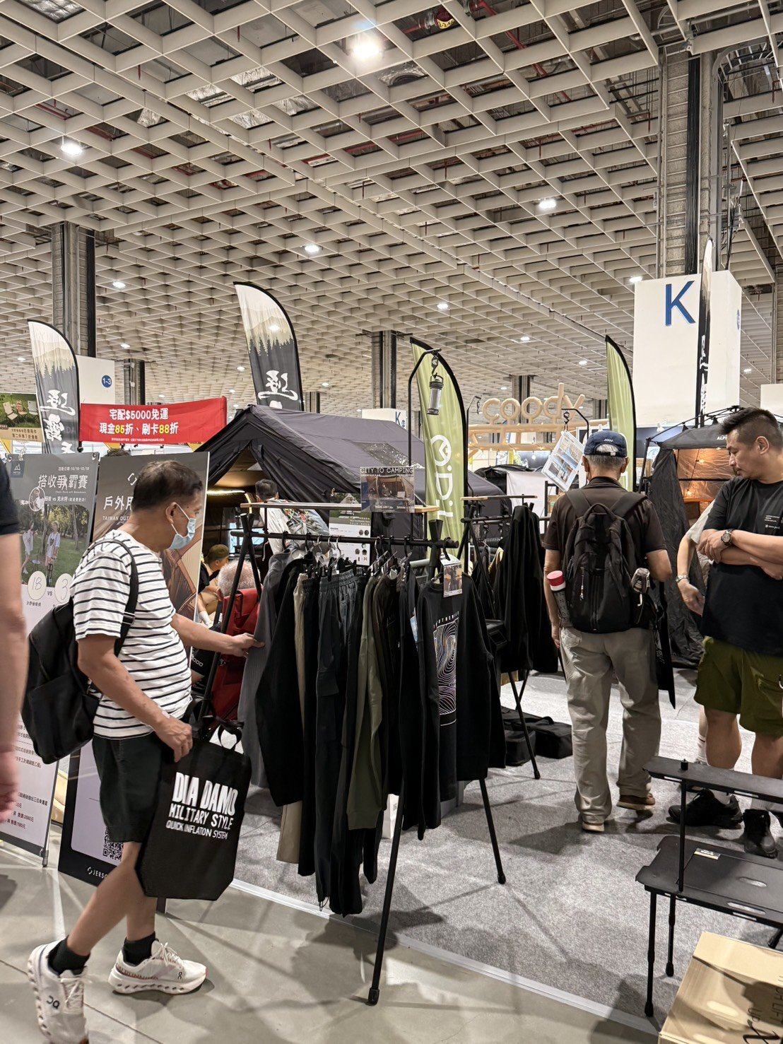 戶外展現場顧客翻看衣桿上的服飾