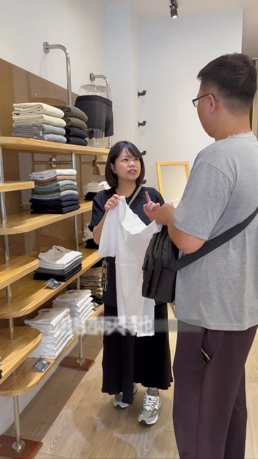 店員遞上衣物讓顧客感受材質