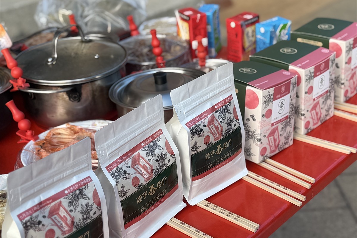 供桌近景，三包七月流火半磅包立在紅桌面上，後面是濾掛盒與湯鍋，每包前面都擺了一雙筷子