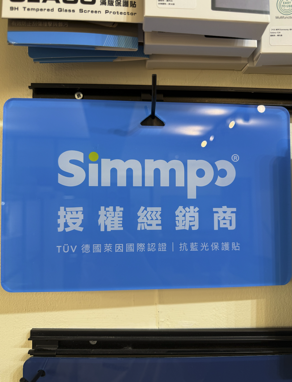 Simmpo 官方授權經銷商標示牌,標示 TÜV 德國萊因國際認證抗藍光保護貼,懸掛於 DADO3C 高雄三民區門市