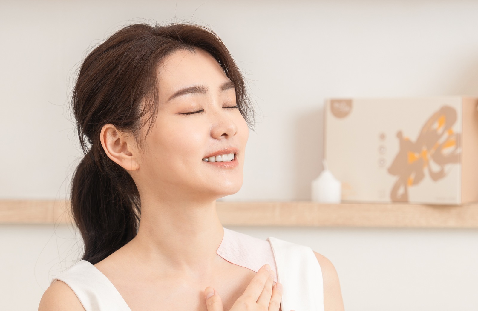 女性坐在居家沙發上閉眼放鬆，一手輕放胸前