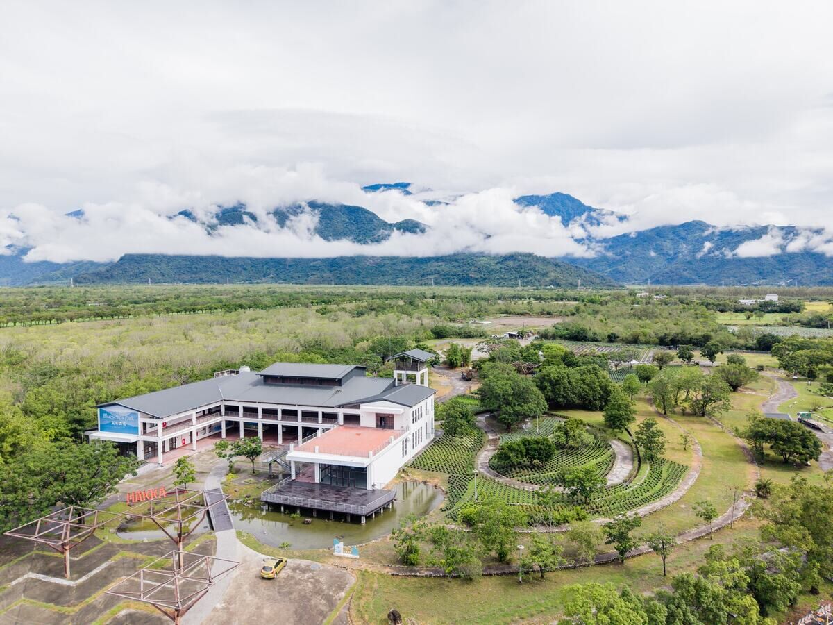 Aerial view of Blueseeds Park and the open fields beneath the mountains
